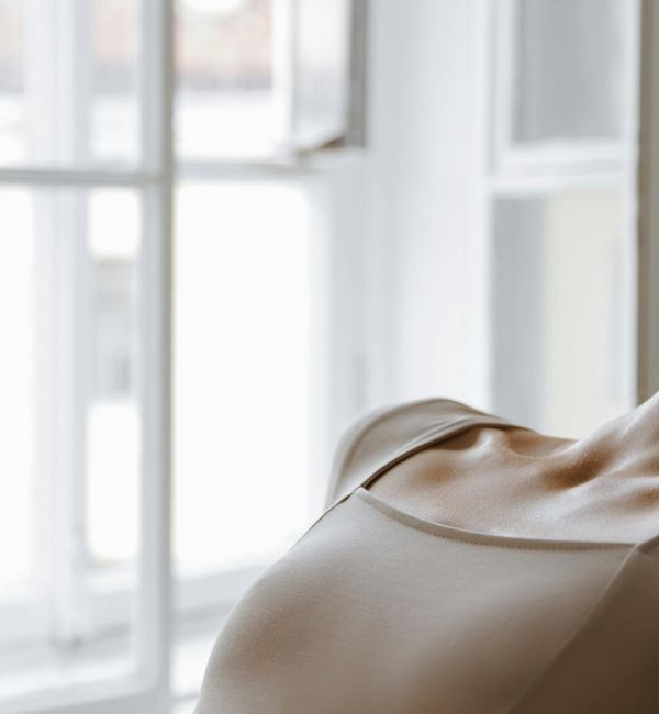 Person meditating peacefully by a window with soft morning light.